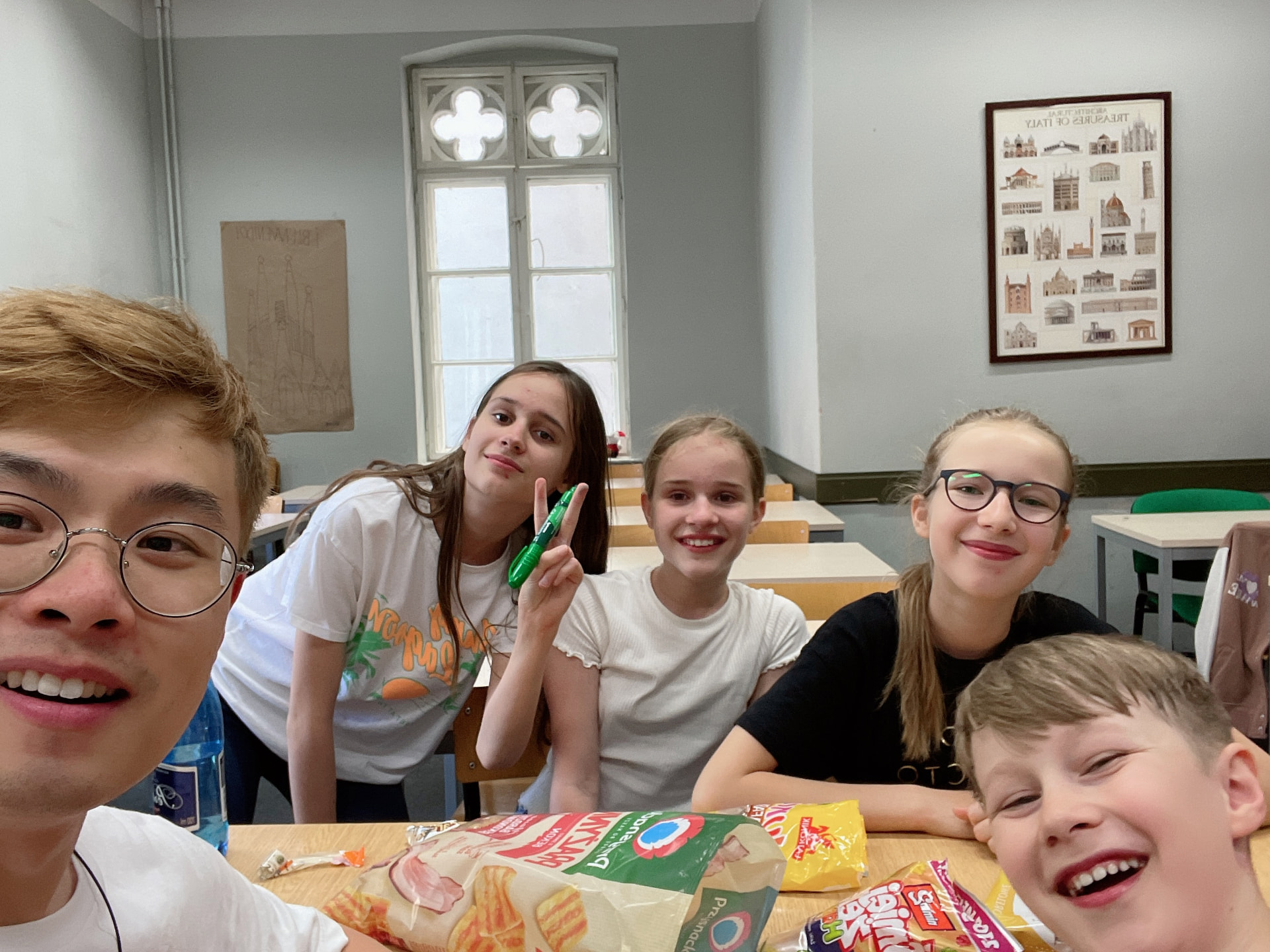 Zihao with young students around a classroom table
